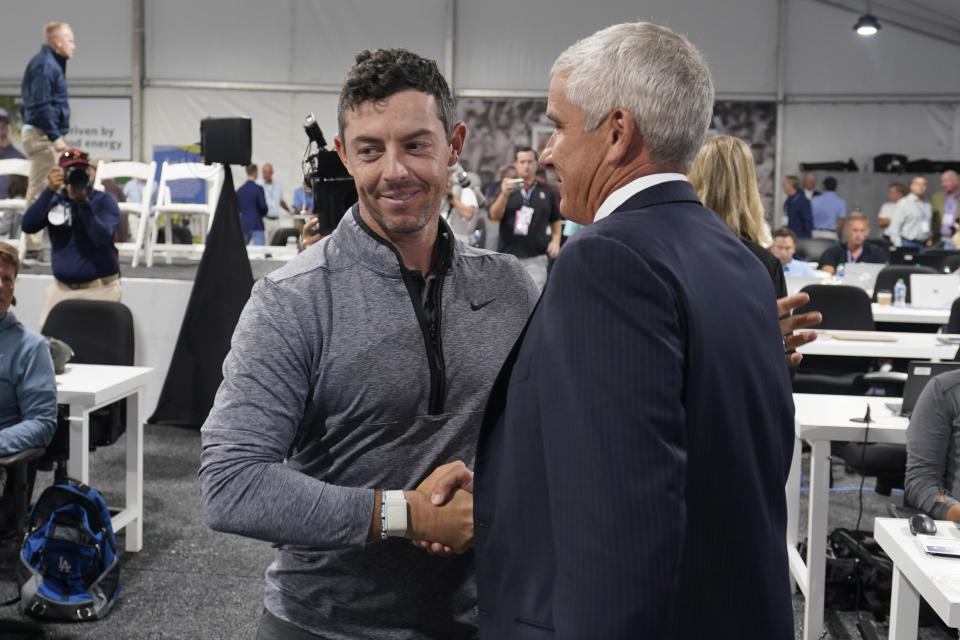 Rory McIlroy, of Northern Ireland, left, shakes hands with PGA Tour Commissioner Jay Monahan after a press conference at East Lake Golf Club prior to the start of the Tour Championship golf tournament Wednesday Aug 24, 2022, in Atlanta, Ga. (AP Photo/Steve Helber)