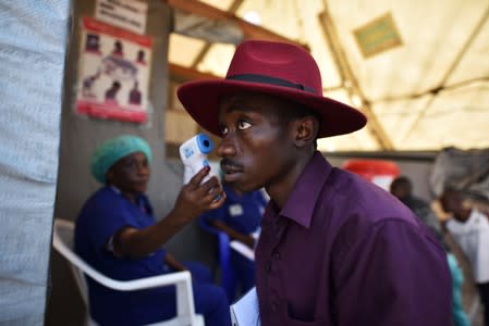 A health worker checks the temperature of a man as part of the ebola screening upon entering the General Hospital in Goma