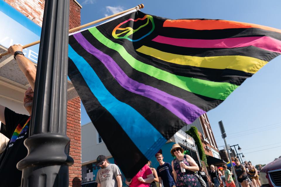 A rainbow flag with a peace sign is waved by an LGBTQ rights supporter during a pride march in Topeka's NOTO district last summer.