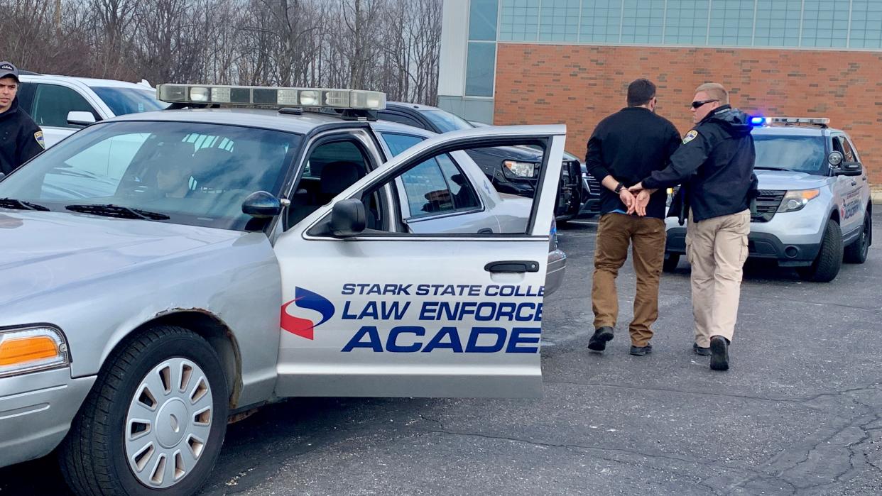 Canton police cadet Ty Cowling leads a suspect to his cruiser during traffic stop training at the Stark State College law enforcement academy in Jackson Township.