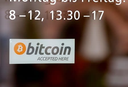 A sticker reading "Bitcoin accepted here" is displayed at the entrance of the Stadthaus town hall in Zug, Switzerland, August 30, 2016. REUTERS/Arnd Wiegmann