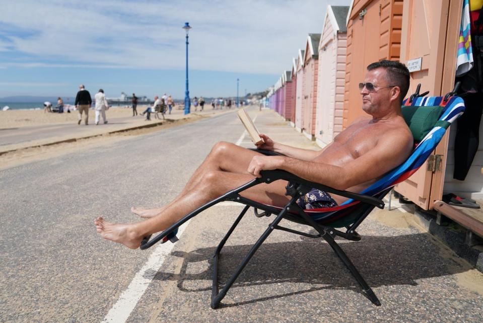 Stuart Henderson enjoys sunshine from his beach hut on Bournemouth beach (PA) (PA Archive)