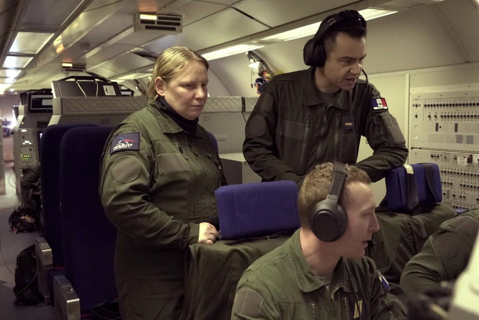 Crew members analyze data on monitors aboard a French military AWACS surveillance plane as it flies a 10-hour mission Tuesday, Jan. 9, 2024, to eastern Romania for the NATO military alliance. With a powerful radar that rotates six times a minute on top of the planes, AWACS can detect targets over hundreds of kilometers (miles). One AWACS can surveil an area the size of Poland; three can cover all of central Europe, NATO says. (AP Photo/John Leicester)