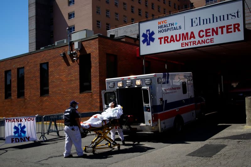 Paramedics wheel a patient into Elmhurst Hospital during outbreak of coronavirus disease (COVID-19) in New York