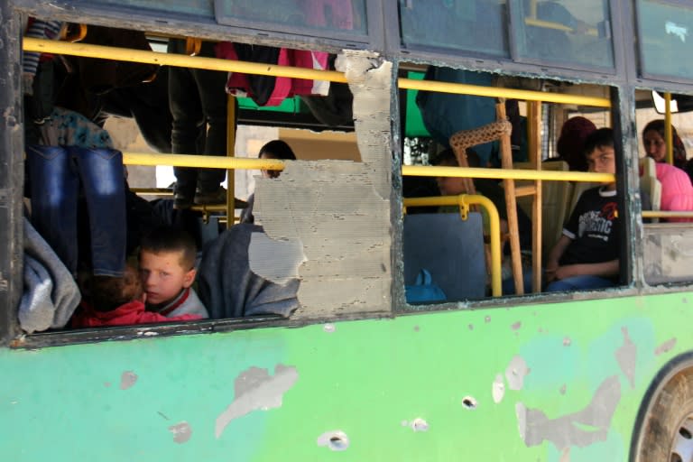 Syrian evacuees from the government-held towns of Fuaa and Kafraya sit in a bus at the rebel-held transit point of Rashidin on April 20, 2017, where they were held up for 48 hours