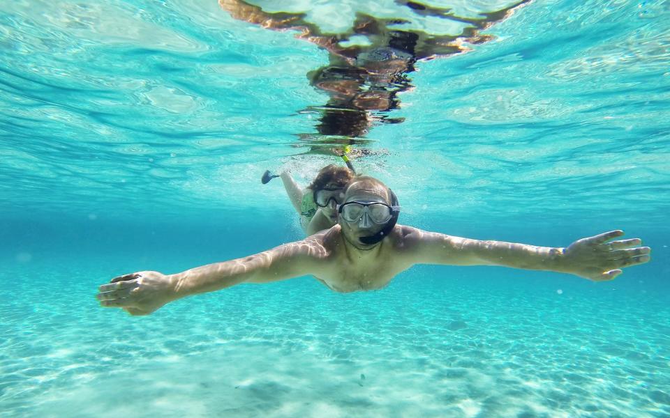 Father and son diving in the Blue Lagoon - Getty