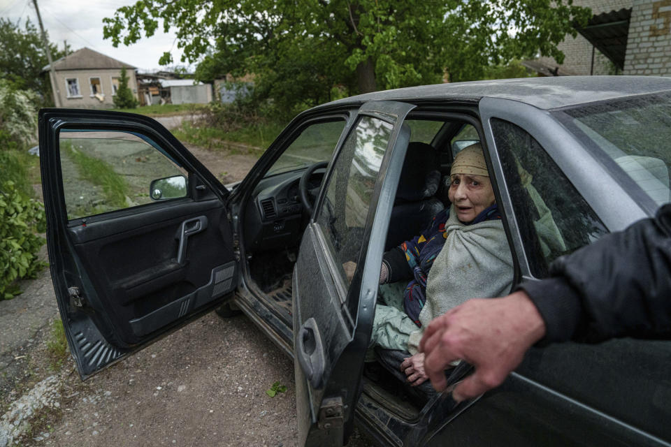A woman sits in the car of her son during evacuation after a Russian airstrike in Vovchansk, Ukraine, on Saturday, May 11, 2024. (AP Photo/Evgeniy Maloletka)
