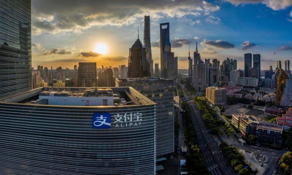 High-level view of skyscrapers in front of a  sunset in Shanghai. A building bearing the Alipay logo is closest to the camera