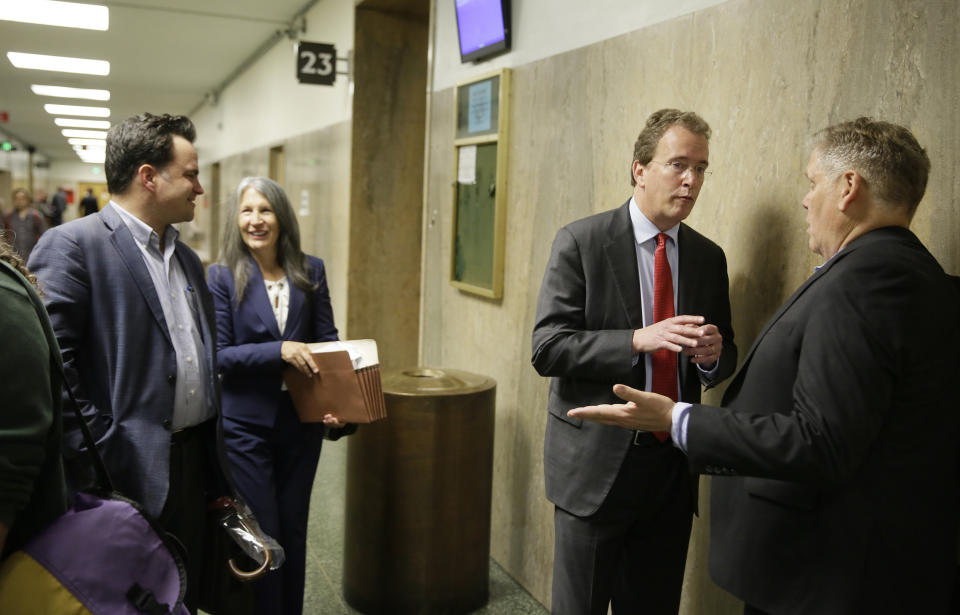 In this photo taken Tuesday, May 21, 2019, from left, David Snyder, an attorney with the First Amendment Coalition, attorney Duffy Carolan, and Thomas Burke, attorney for freelance journalist Bryan Carmody, talk outside a courtroom before a hearing in San Francisco. Advocates of the press pushed back against a San Francisco police chief who said a freelance journalist had "crossed the line" in conspiring to steal a police report, saying that it is not a crime to disclose a public record. Carolan, who is representing several media organizations siding with the independent reporter, says that the public has constitutional rights to access public records. (AP Photo/Eric Risberg)