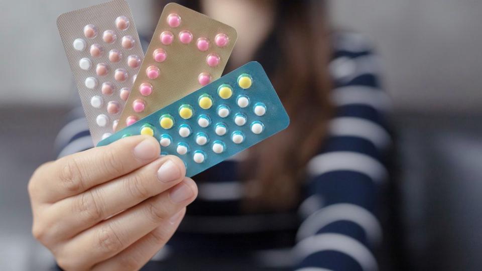 Women holding birth control pills