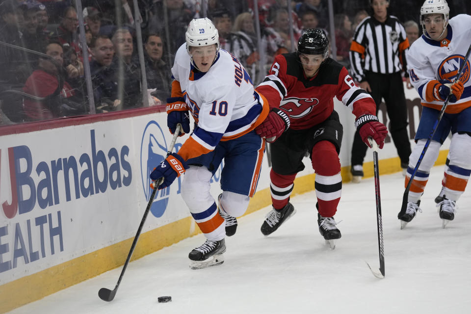 New York Islanders' Simon Holmstrom, left, and New Jersey Devils' John Marino go for the puck during the first period of an NHL hockey game in Newark, N.J., Tuesday, Nov. 28, 2023. (AP Photo/Seth Wenig)