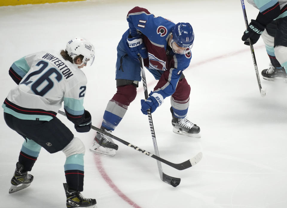 Seattle Kraken center Ryan Winterton (26) fights for control of the puck with Colorado Avalanche center Andrew Cogliano (11) in the first period of an NHL hockey game Thursday, Nov. 9, 2023, in Denver. (AP Photo/David Zalubowski)