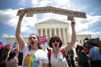 <p>Protesters Celina Scott-Buechler (R) and Lisset Pino (L) demonstrate against U.S. President Trump’s travel ban as protesters gather outside the U.S. Supreme Court following a court issued immigration ruling June 26, 2018 in Washington, D.C. (Photo: Win McNamee/Getty Images) </p>