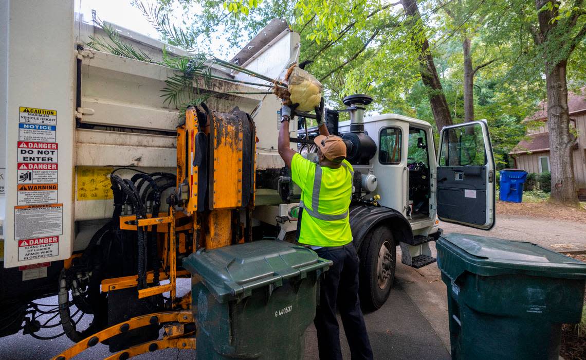 Raleigh Solid Waste Services employee Alonzo Adams removes a discarded house plant from his truck that was wrongly placed in a household waste receptacle during curbside pick-up on Wednesday, July 17, 2024 in Raleigh, N.C.