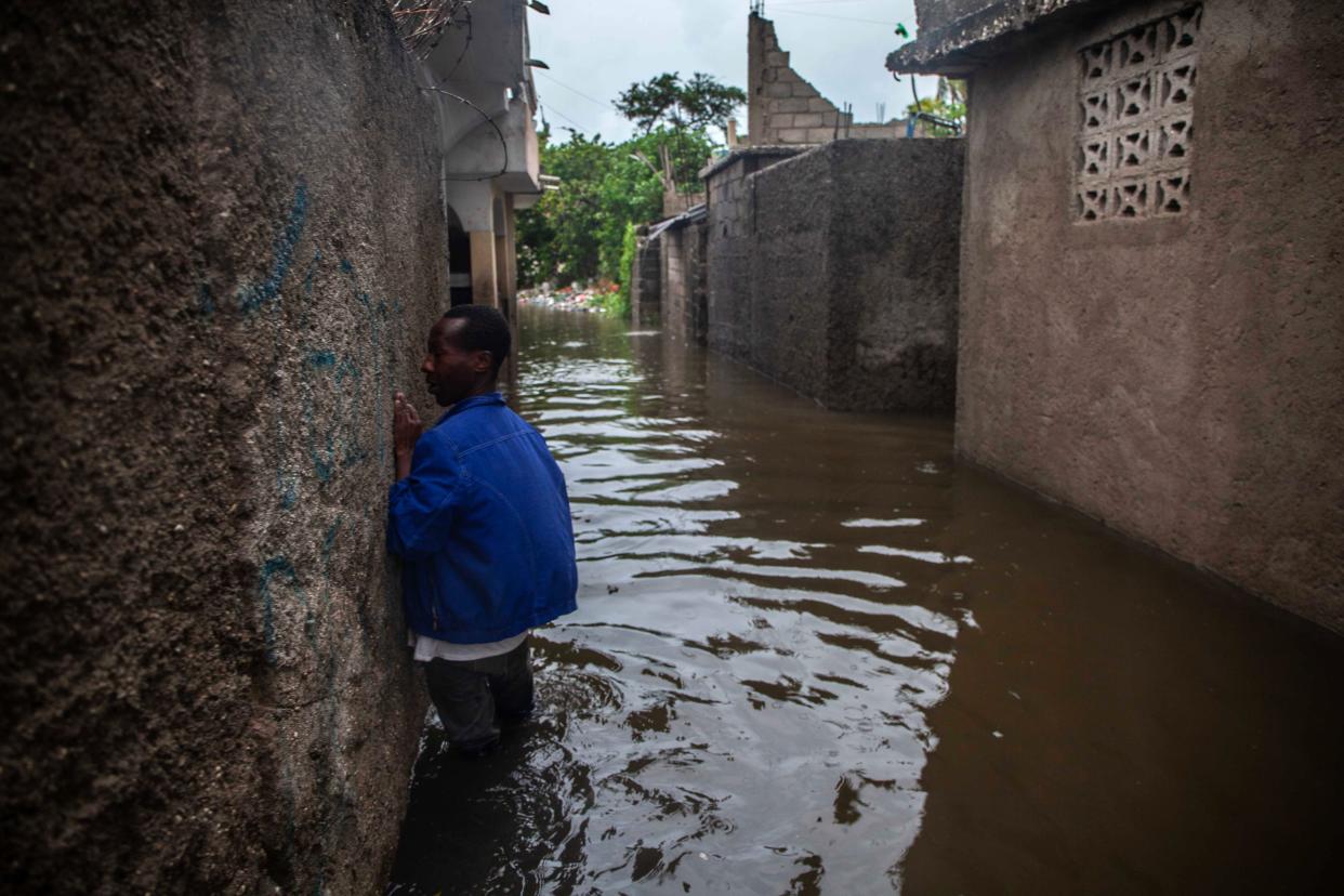 A man walks through a flooded area as heavy rain brought by tropical storm Grace hits Haitians just after a 7.2-magnitude earthquake struck Haiti on Aug. 17, 2021, in Les Cayes, Haiti.