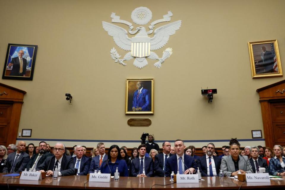 people sit at table in congressional chamber