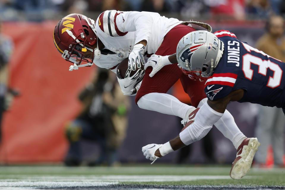 Washington Commanders wide receiver Jahan Dotson, left, scores a touchdown as New England Patriots cornerback Jonathan Jones, right, tries to defend in the second half of an NFL football game, Sunday, Nov. 5, 2023, in Foxborough, Mass. (AP Photo/Charles Krupa)