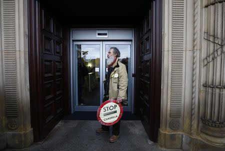 A man holding a sign stands outside the County Hall during an anti-fracking protest in Preston, northern England January 28, 2015. REUTERS/Darren Staples