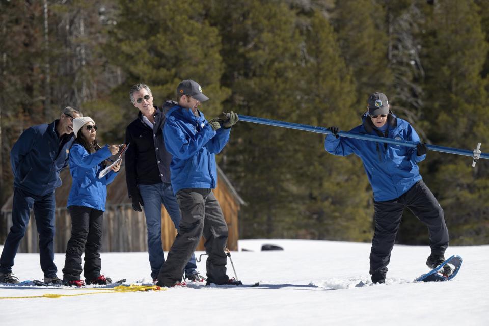 Gov. Gavin Newsom watches the Department of Water Resources team performs its April snow survey at Phillips Station in El Dorado County on Tuesday, April 2, 2024. (Paul Kitagaki Jr./The Sacramento Bee via AP, Pool)