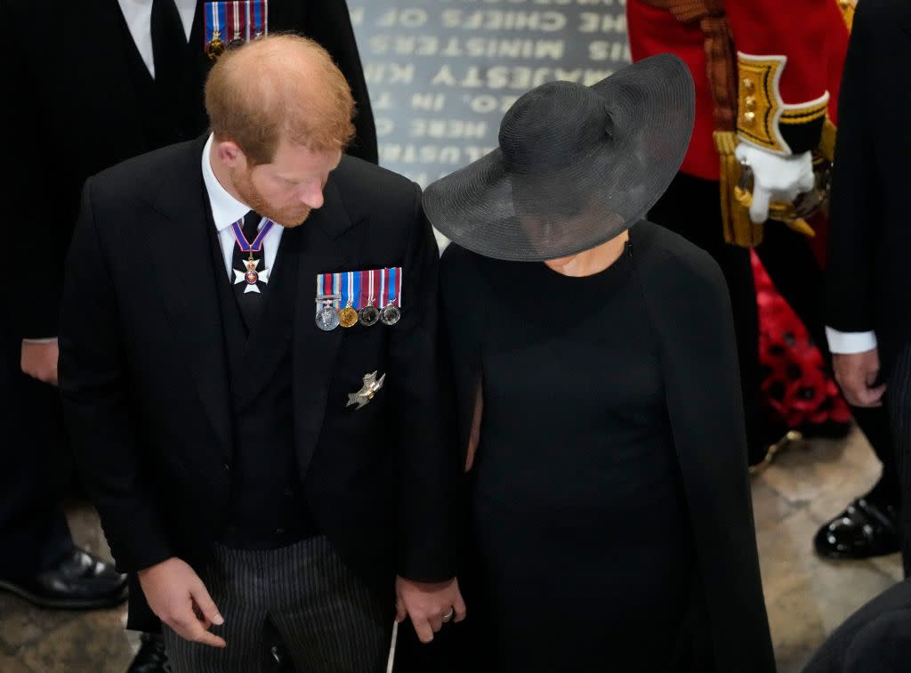 The Duke and Duchess of Sussex appear to hold hands as they follow the coffin of the Queen out of Westminster Abbey. (Getty Images)