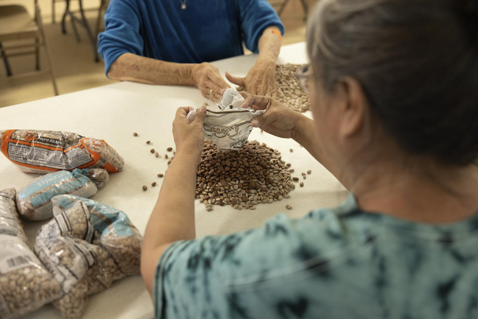 Ethel Humble, an elder at the Springfield United Methodist Church in Okemah, Okla., hands out a portion of the church's famous fried pork at their annual wild onion dinner on April 6, 2024. The church is on the Muscogee Nation's reservation, where the meals using wild onions picked by the community are an annual tradition. (AP Photo/Brittany Bendabout)