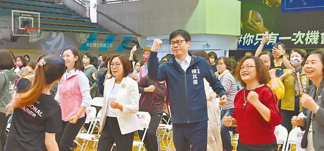 高雄市長陳其邁（前右三）、議長康裕成（前右四）4日參加婦女節活動，跟隨老師的指導做運動。（林瑞益攝）