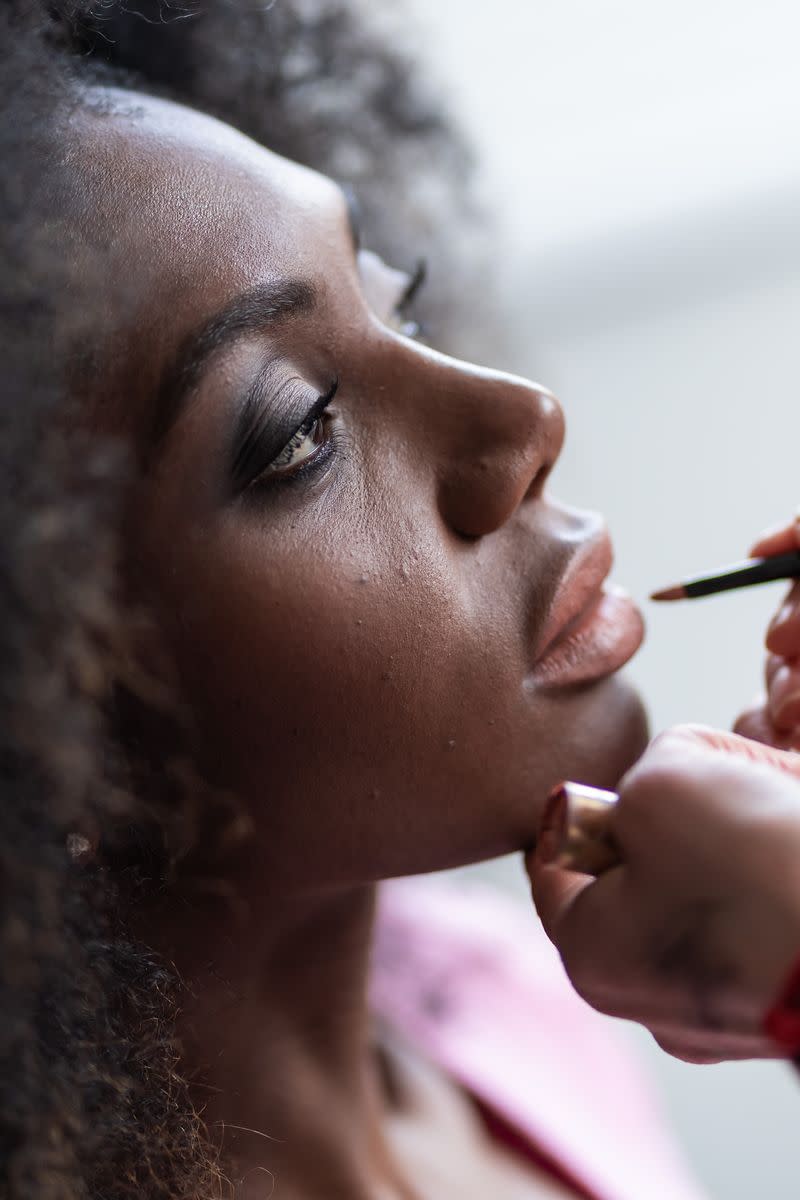 A woman having makeup applied by someone else