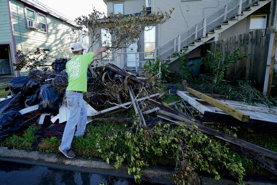 Caleb Cormier moves debris after Hurricane Delta moved through, Saturday, Oct. 10, 2020, in Lake Charles, La. Delta hit as a Category 2 hurricane with top winds of 100 mph (155 kph) before rapidly weakening over land. (AP Photo/Gerald Herbert)