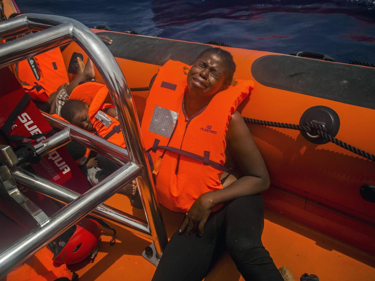 A woman cries after being rescued by aid workers of Spanish NGO Proactiva Open Arms in the Mediterranean Sea, about 15 miles north of Sabratha, Libya: Santi Palacios/AP