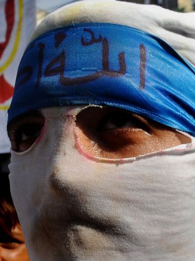 A masked Pakistani activist of the hardline Sunni party Jamaat-e-Islami marches during a protest against an anti-Islam movie near the US consulate in Lahore on September 19. The film, made by extremist Christians in the United States, has triggered more than a week of furious protests and attacks across the Muslim world, which have killed least 30 people