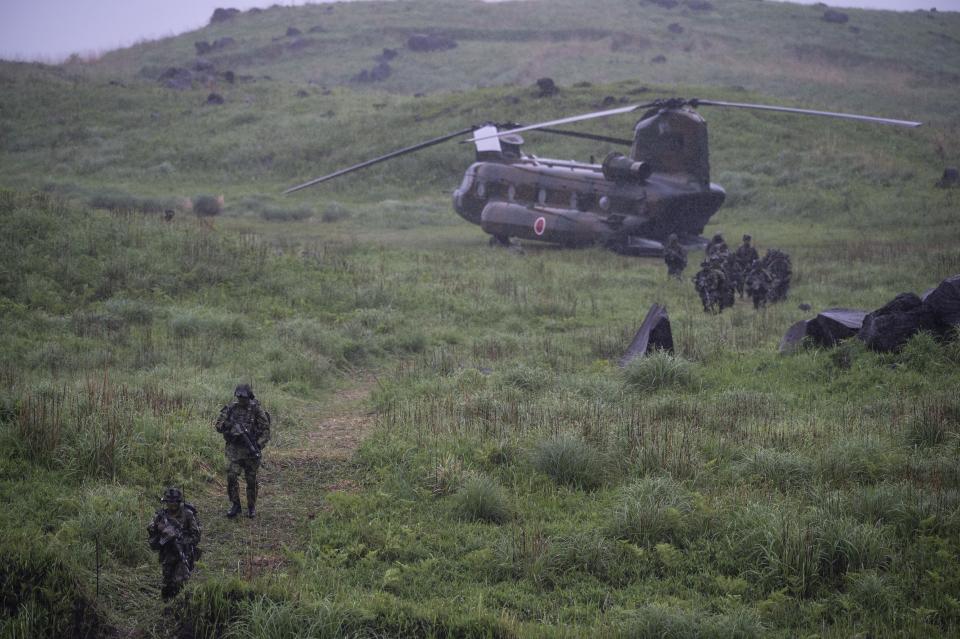 Japan Self-Defense Force soldiers walk out of a Chinook helicopter during a joint military drill between Japan Self-Defense Force, French army and U.S. Marines, at the Kirishima exercise area in Ebino, Miyazaki prefecture, southern Japan Saturday, May 15, 2021. (Charly Triballeau/Pool Photo via AP)