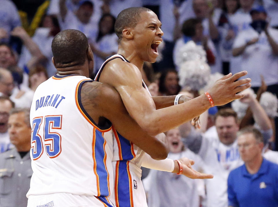 Oklahoma City Thunder forward Kevin Durant (35) celebrates with teammate Russell Westbrook, right, at the end of Game 5 of the Western Conference semifinal NBA basketball playoff series against the Los Angeles Clippers in Oklahoma City, Tuesday, May 13, 2014. Oklahoma City won 105-104. (AP Photo)