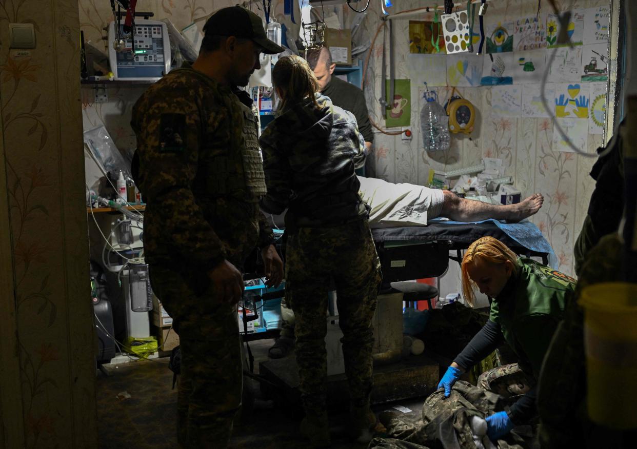 Four medics treat a wounded Ukrainian serviceman near Bakhmut, Donestsk (AFP via Getty Images)