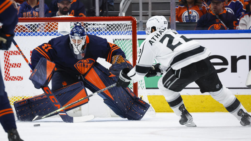 Los Angeles Kings center Andreas Athanasiou, right, tries to get to a shot off against Edmonton Oilers goalie Mike Smith during the second period in Game 7 of a first-round series in the NHL hockey Stanley Cup playoffs Saturday, May 14, 2022, in Edmonton, Alberta. (Jeff McIntosh/The Canadian Press via AP)