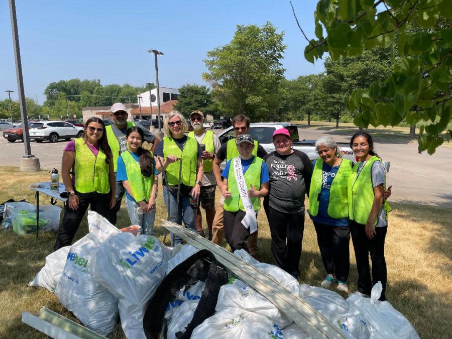 Representatives of Partners of Scott County Watershed, volunteers and Miss Scott County’s Brittany Costello pose with trash they picked-up near the Fairmount Wetlands in Davenport.