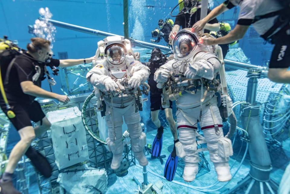 NASA astronauts Stephen G. Bowen, left, wearing an Extravehicular Mobility Unit spacesuit, and Zena M. Cardman testing a prototype Z-2.5 spacesuit in the NBL in July 2021.