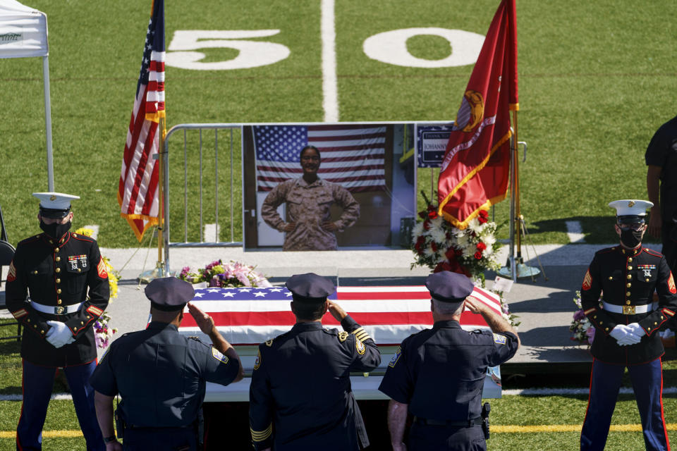 Law enforcement members salute the casket of Sgt. Johanny Rosario Pichardo, a U.S. Marine who was among 13 service members killed in a suicide bombing in Afghanistan, during a public wake at Veterans Memorial Stadium in her hometown of Lawrence, Mass., Tuesday, Sept. 14, 2021. (AP Photo/David Goldman)