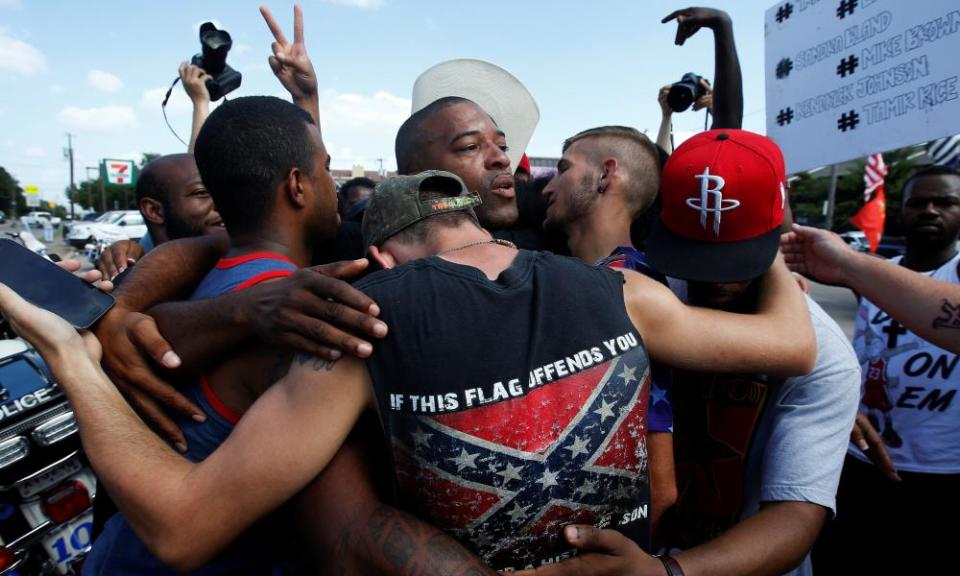 People, including a man wearing a confederate flag, hug after a prayer circle after a Black Lives Matter protest in Dallas in 2016.