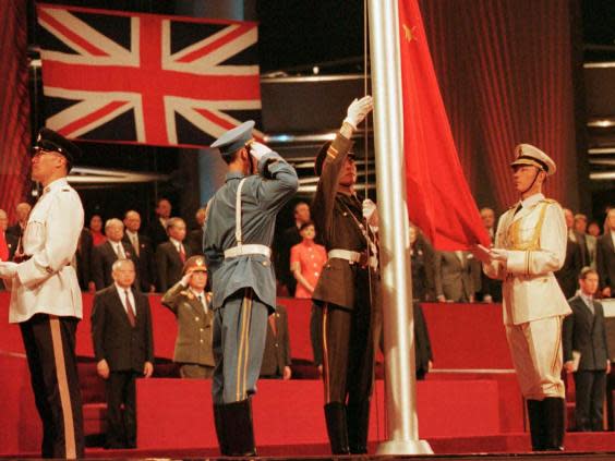 Chinese soldiers raise the country’s flag at the Hong Kong convention centre to mark the moment the British colony reverted to Chinese rule in July 1997 (AP)