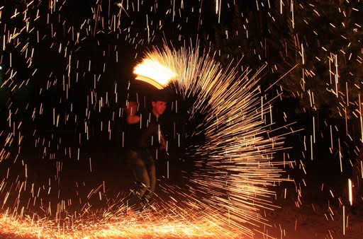 A Palestinian boy plays with fireworks as he celebrates the start of the Muslim holy month of Ramadan in the West Bank city of Nablus, Thursday, July 19, 2012. (AP Photo/Nasser Ishtayeh)