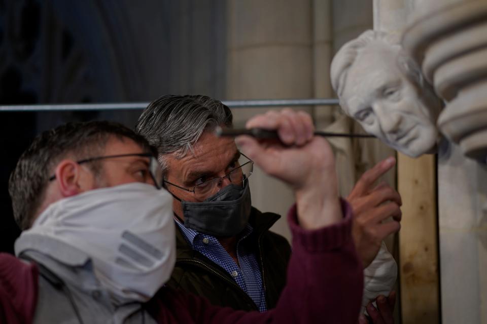 Artist Chas Fagan, right, works to fine-tune his sculpture of Holocaust survivor and Nobel Peace Prize-winning author Elie Wiesel with stone carver Sean Callahan in the Human Rights Porch of the Washington National Cathedral.