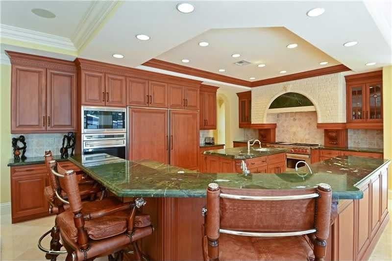 <p>The kitchen features wood cabinets and a large breakfast bar. (Realtor.com) </p>