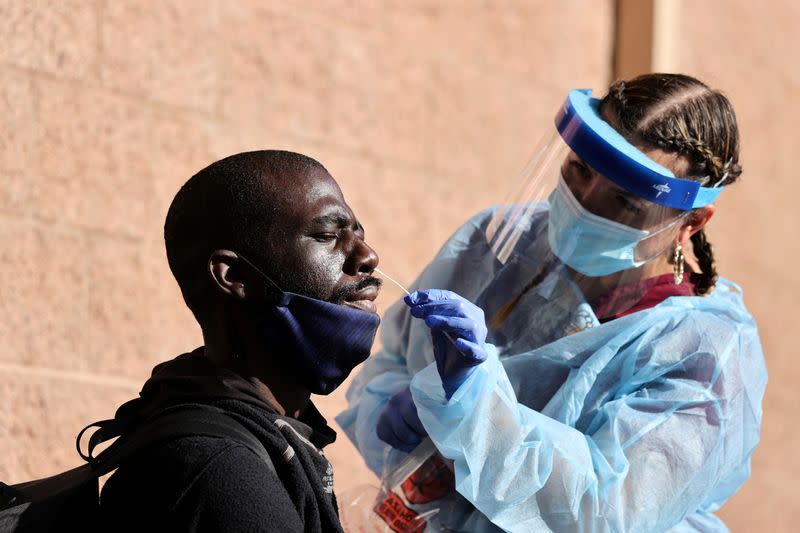 A man takes a coronavirus test at a Los Angeles Mission homeless shelter Thanksgiving meal giveaway in Los Angeles