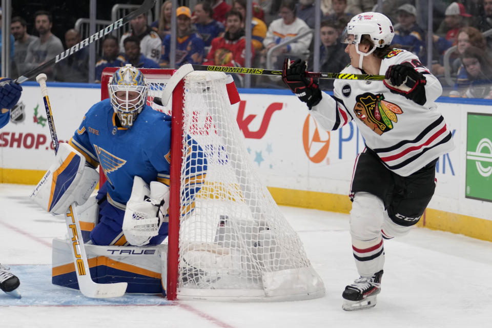 Chicago Blackhawks' Connor Bedard, right, scores past St. Louis Blues goaltender Jordan Binnington during the first period of an NHL hockey game Saturday, Dec. 23, 2023, in St. Louis. (AP Photo/Jeff Roberson)