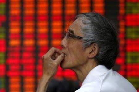 An investor looks at an electronic board showing stock information at a brokerage house in Shanghai, China, July 10, 2015. REUTERS/Aly Song