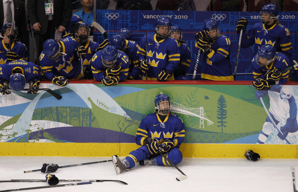 Sweden's hockey team watch as Finland players celebrate their win in overtime in their women's ice hockey bronze medal game at the Vancouver 2010 Winter Olympics February 25, 2010. REUTERS/Shaun Best (CANADA)