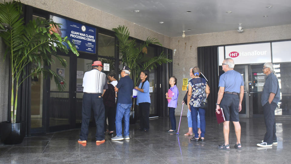 In this Friday, Feb. 7, 2020 photo, people wait in line at the Guam war claims office in Tamuning, Guam. The 1941 Japanese invasion of Guam, which happened on the same December day as the attack on Hawaii's Pearl Harbor, set off years of forced labor, internment, torture, rape and beheadings. Now, more than 75 years later, thousands of people on Guam, a U.S. territory, are expecting to get long-awaited compensation for their suffering at the hands of imperial Japan during World War II. (AP Photo/Anita Hofschneider)
