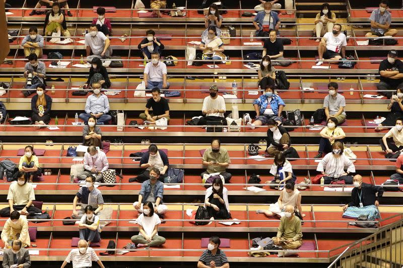 Spectators wearing protective masks practice social distancing as they watch the July Grand Sumo Tournament in Tokyo