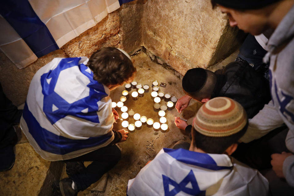 Israeli youth light candles in the shape of the Star of David at the site of a shooting attack that killed an Israeli man in Jerusalem's Old City, Sunday, Nov. 21, 2021. A Hamas militant opened fire in Jerusalem's Old City, killing the 26-year-old Israeli and wounding four other people before he was fatally shot by Israeli police. (AP Photo/Ariel Schalit)