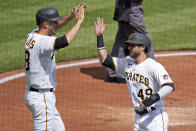 Pittsburgh Pirates' Jacob Stallings, left, and Dustin Fowler, right, celebrate after scoring on a single during the second inning of a baseball game in Pittsburgh, Sunday, April 11, 2021. (AP Photo/Gene J. Puskar)